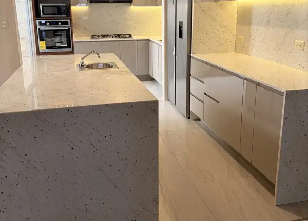 Isla de cocina con cubierta de piedra en cascada hasta el piso
